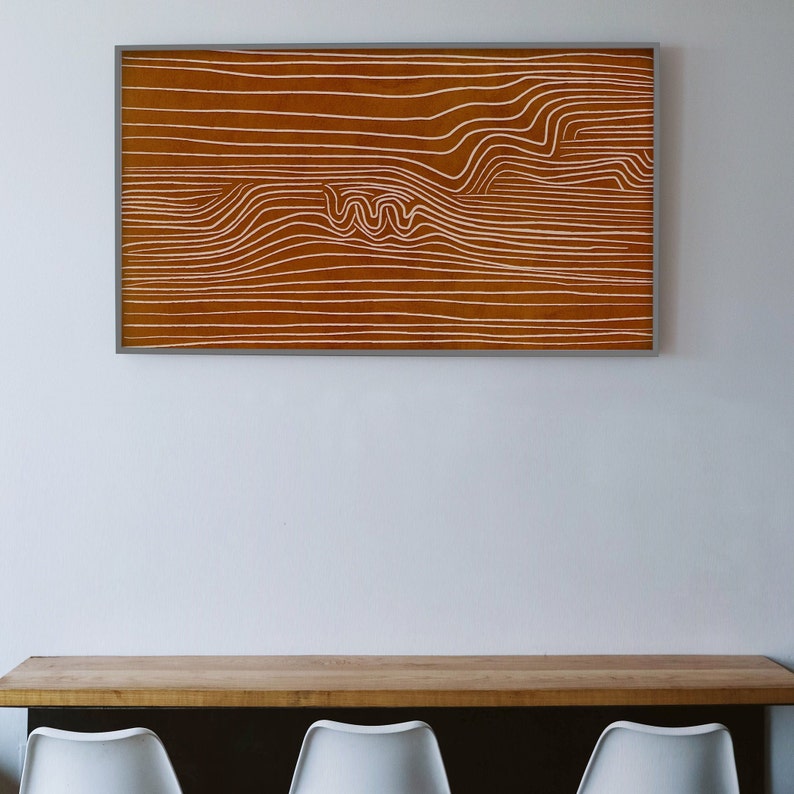 May include: A framed abstract art print with white lines on a brown background. The lines create a wavy pattern.