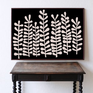 Puede incluir: Arte de pared enmarcado en blanco y negro con un dise&ntilde;o estilizado de plantas de helecho rosadas sobre un fondo negro.
