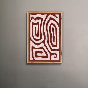 May include: A framed abstract print with a white design of swirling lines on a rust-colored background.