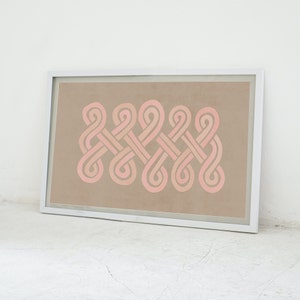K&ouml;nnte beinhalten: Ein gerahmter Druck mit einem geometrischen Design aus rosa und wei&szlig;en, ineinandergreifenden Schleifen auf beigefarbenem Hintergrund.
