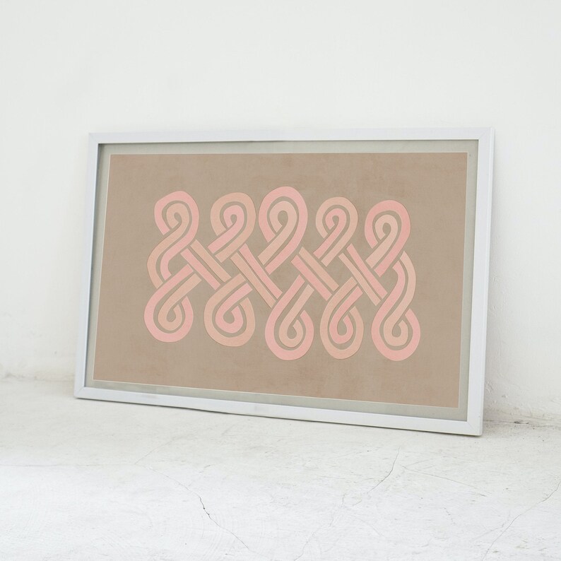 K&ouml;nnte beinhalten: Ein gerahmter Druck mit einem geometrischen Design aus rosa und wei&szlig;en, ineinandergreifenden Schleifen auf beigefarbenem Hintergrund.