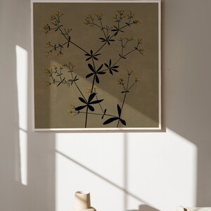 May include: A framed print of a stylized black floral design with yellow flowers on a muted green background.