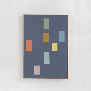 May include: Abstract art print featuring a dark blue background with rectangular shapes in various colors, including orange, yellow, and green. The artwork is framed in a thin, natural wood frame, creating a modern aesthetic.