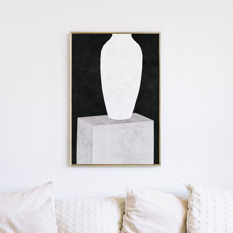 May include: A white vase sits on a gray cube against a black background. The vase is tall and slender with a rounded base and a wide opening at the top. The cube is square and has a textured surface. The background is a solid black.
