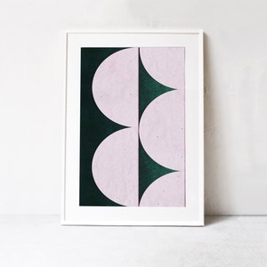 May include: Abstract art print featuring a geometric design of overlapping pink and dark green semi-circles.