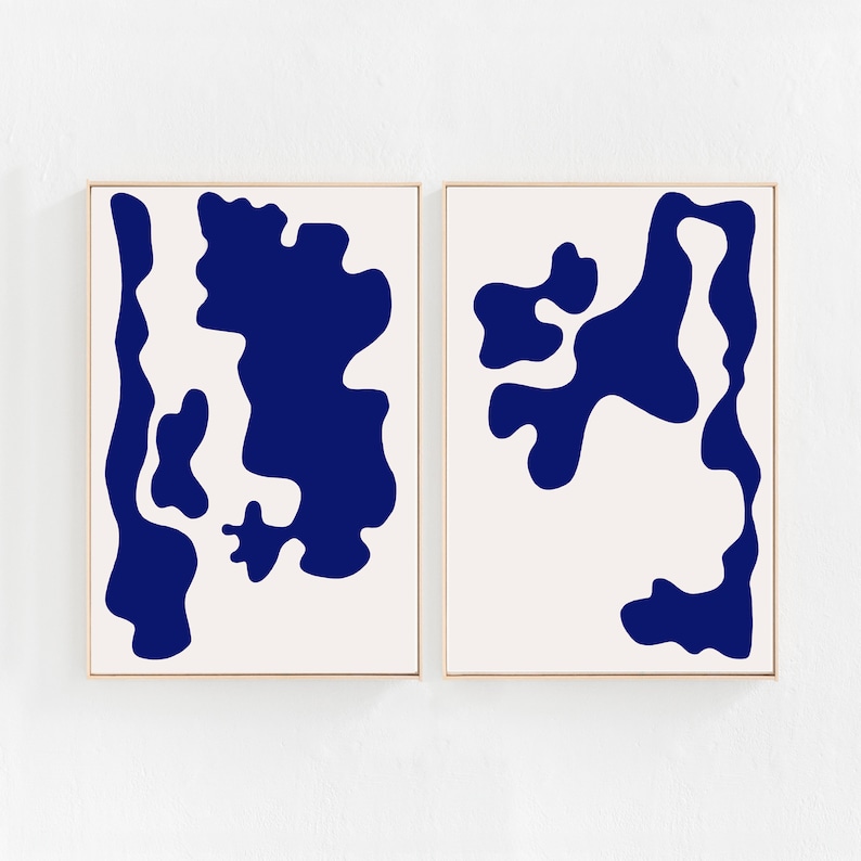 May include: Two framed abstract art prints with a white background and blue abstract shapes. The shapes are organic and resemble clouds or water.