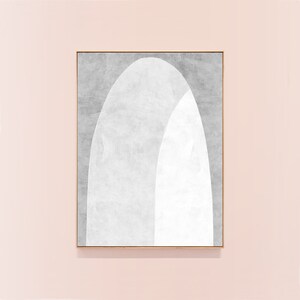 Peut inclure: Une impression d'art abstrait encadr&eacute;e avec un design blanc et gris. Le design pr&eacute;sente deux arches qui se chevauchent, une blanche et une grise, cr&eacute;ant une esth&eacute;tique moderne et minimaliste.