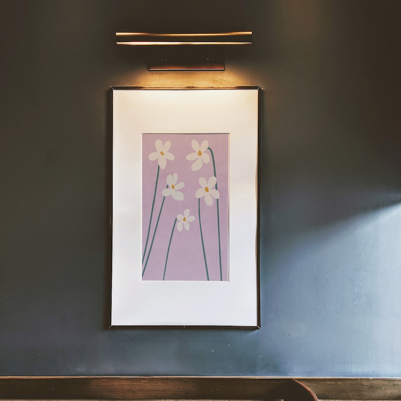 May include: A framed print of a minimalist floral design featuring five white flowers with yellow centers on a light purple background.