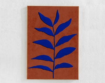 May include: A blue stylized leaf design on a terracotta background. The painting is framed in a thin gold frame.
