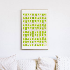 May include: A framed print with a geometric pattern of green and white semi-circles. The print is in a gold frame and is hanging on a white wall.