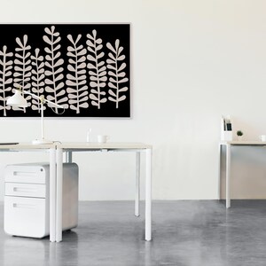 Puede incluir: Dos escritorios blancos con patas de metal blanco y un archivador blanco. Una impresi&oacute;n enmarcada en negro con un dise&ntilde;o abstracto blanco cuelga en la pared detr&aacute;s de los escritorios.