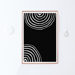 Pode incluir: Impress&atilde;o de arte abstrata em preto e branco com dois c&iacute;rculos conc&ecirc;ntricos em um estilo minimalista. A impress&atilde;o &eacute; emoldurada em uma moldura de cor cobre.