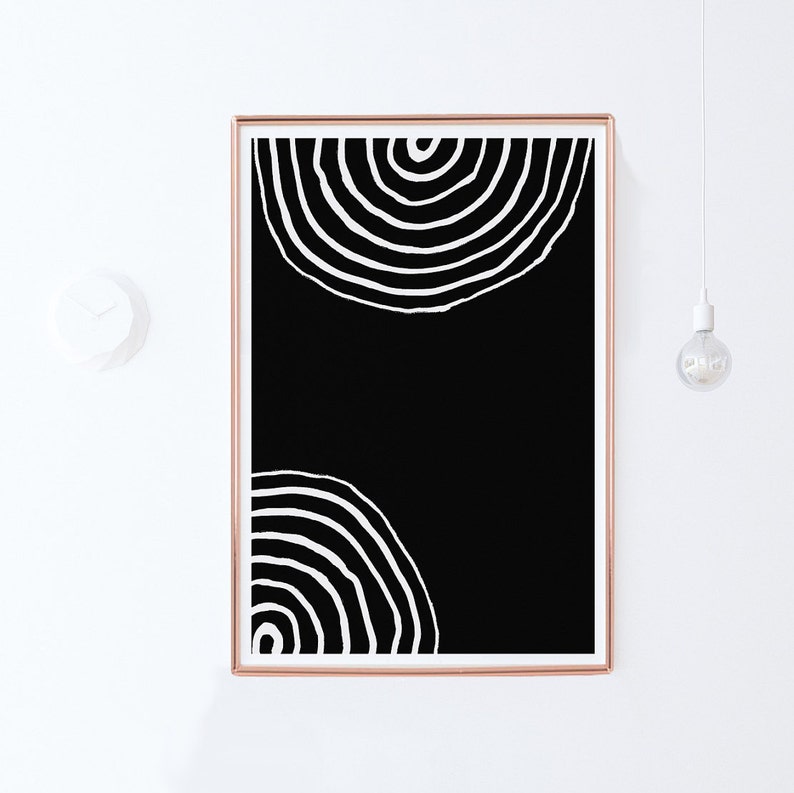 Pode incluir: Impress&atilde;o de arte abstrata em preto e branco com dois c&iacute;rculos conc&ecirc;ntricos em um estilo minimalista. A impress&atilde;o &eacute; emoldurada em uma moldura de cor cobre.