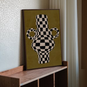 Pode incluir: Um vaso xadrez preto e branco com fundo dourado. O vaso tem um design &uacute;nico e abstrato.