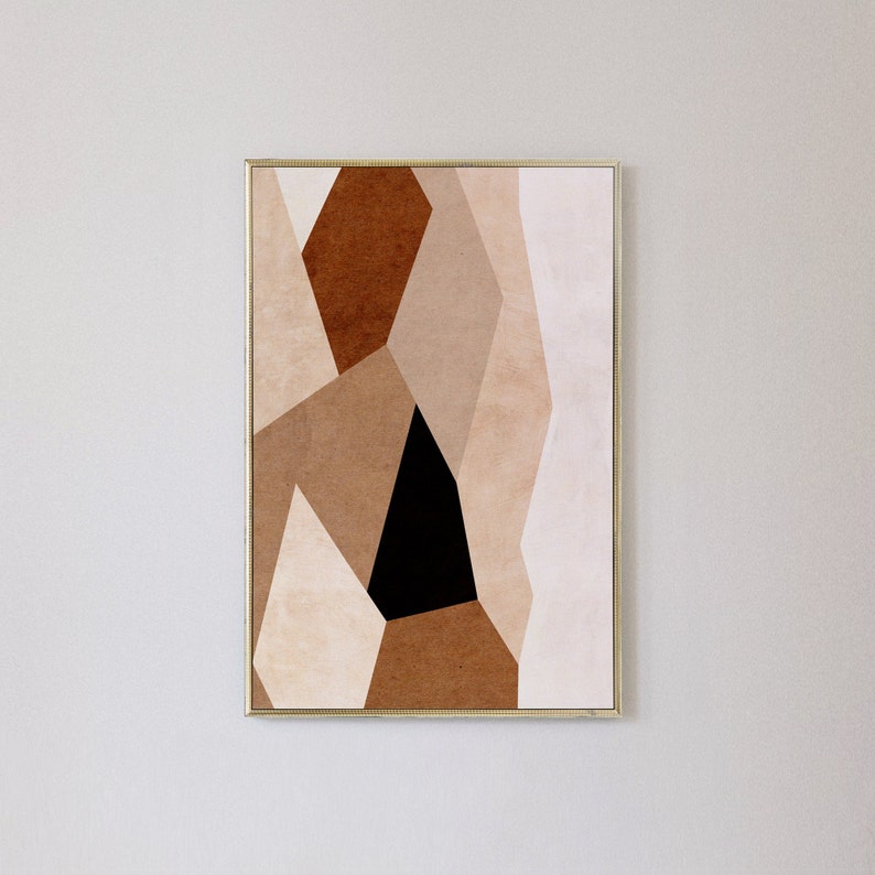 May include: Abstract geometric art print with a black, brown, and beige color scheme. The print is framed in a gold frame.