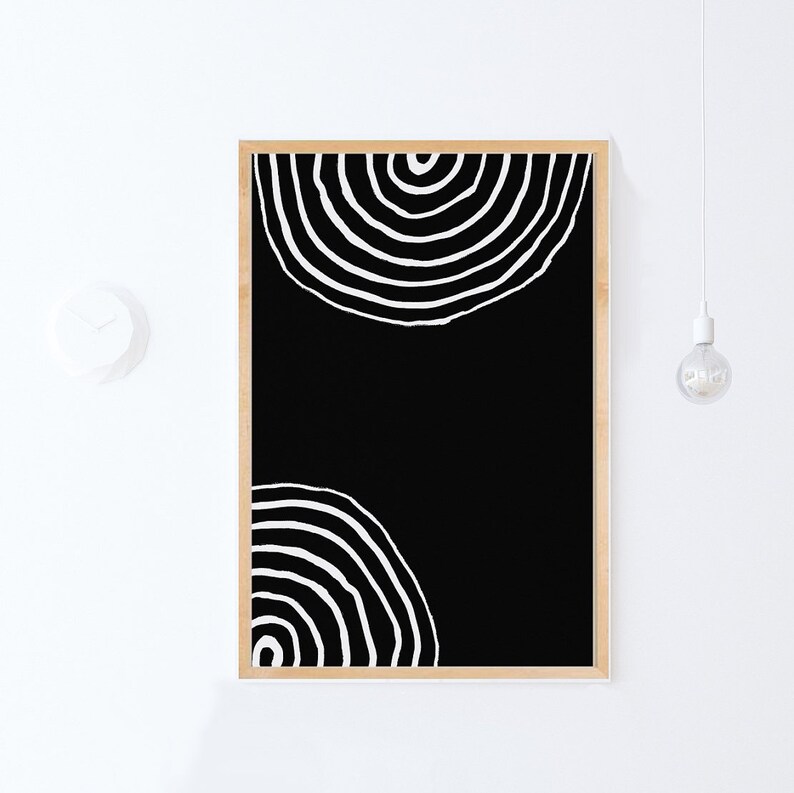 Pode incluir: Impress&atilde;o de arte abstrata em preto e branco com dois c&iacute;rculos conc&ecirc;ntricos em uma moldura de madeira.