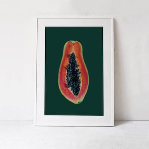 May include: A halved papaya with black seeds against a dark green background. The papaya is a vibrant orange-red color.