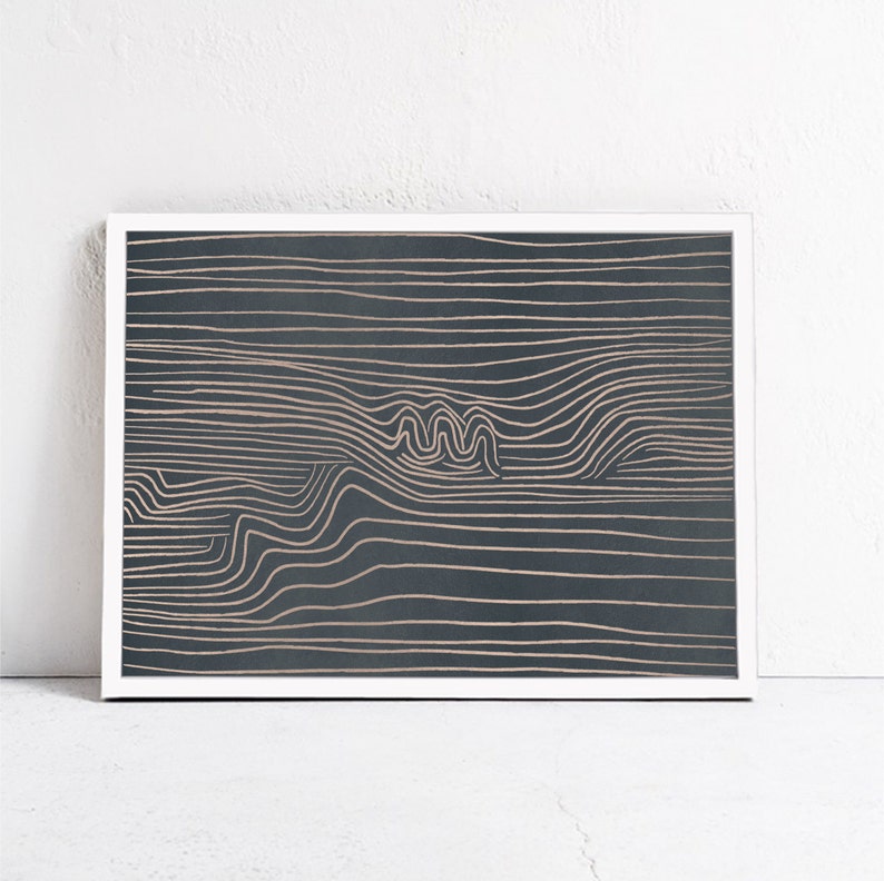 May include: Abstract art print with a white frame. The print features a dark blue background with a pattern of thin, wavy, light brown lines.
