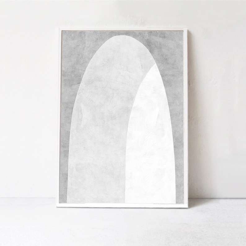 Peut inclure: Une impression d'art abstrait encadr&eacute;e avec un sch&eacute;ma de couleurs blanc et gris. L'impression pr&eacute;sente deux arches qui se chevauchent, cr&eacute;ant un design moderne et minimaliste.