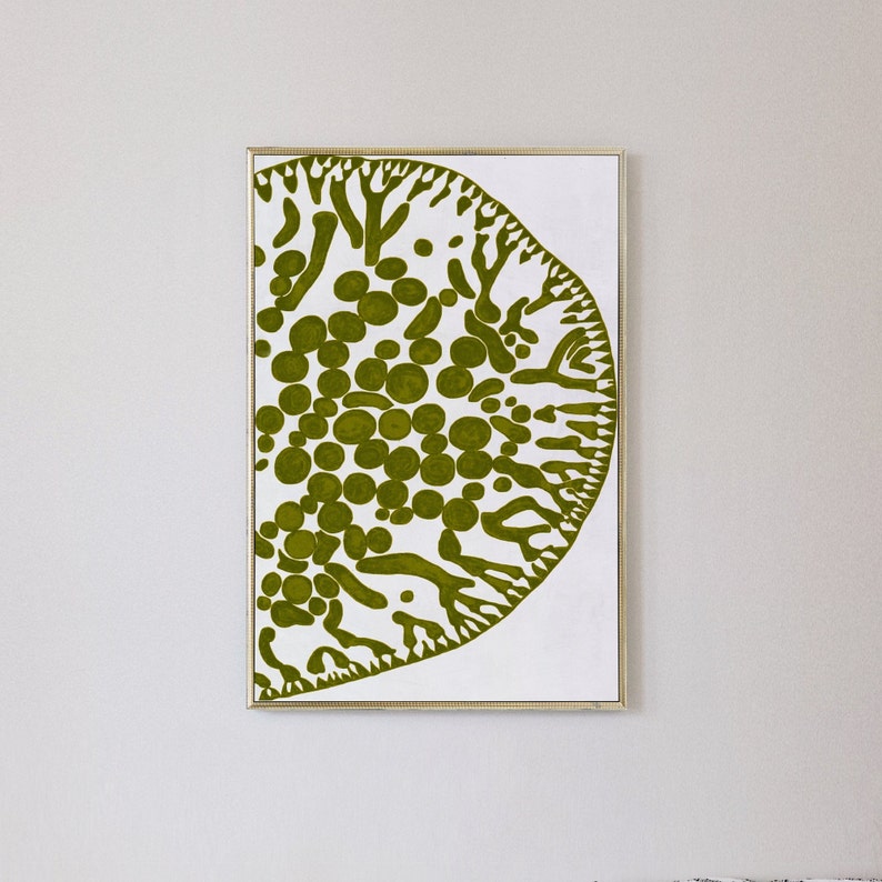 May include: A framed abstract art print featuring a green and white design. The design resembles a stylized tree or plant with a circular shape.