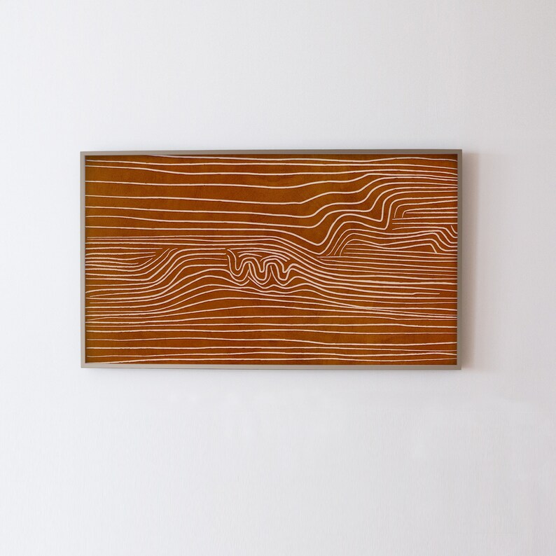 May include: A framed abstract art print with a brown background and white lines creating a wavy pattern.