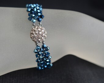 May include: A blue and silver beaded bracelet with a crystal center piece.