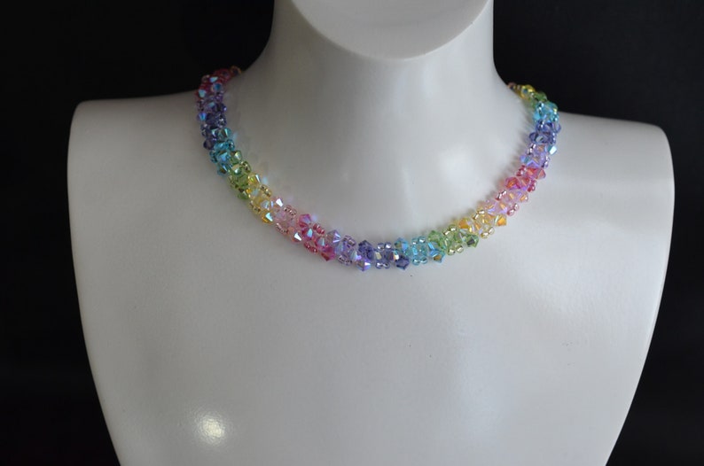 May include: A rainbow crystal necklace with iridescent beads. The necklace is made of small, faceted crystals in shades of red, orange, yellow, green, blue, indigo, and violet.
