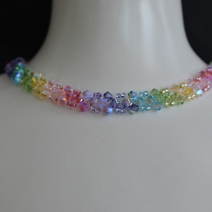 May include: A rainbow crystal necklace with iridescent beads. The necklace is made of small, faceted crystals in shades of red, orange, yellow, green, blue, indigo, and violet.