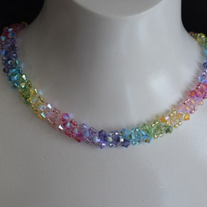 May include: A rainbow-colored crystal bead necklace. The beads are arranged in a gradient pattern, starting with purple and ending with green.