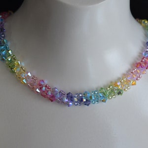 May include: A rainbow crystal necklace with iridescent beads. The necklace is made of small, faceted beads that are strung together in a graduated pattern, starting with purple and ending with green.