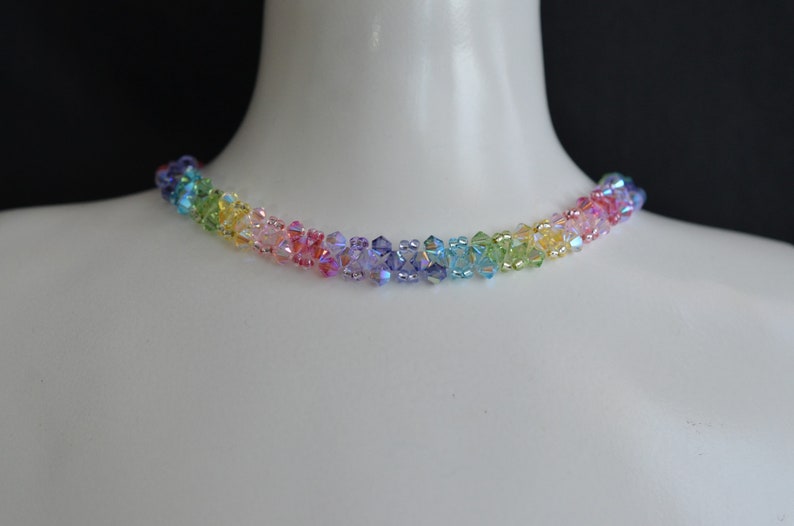 May include: A rainbow crystal choker necklace with small, faceted beads in shades of red, orange, yellow, green, blue, indigo, and violet.
