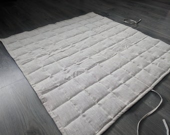 Könnte beinhalten: Eine beige gesteppte Spielmatte mit schlichtem Design. Die Matte hat eine hellbeige Farbe und ist aus einem weichen, komfortablen Stoff gefertigt. Sie ist perfekt für Babys und Kleinkinder zum Spielen.