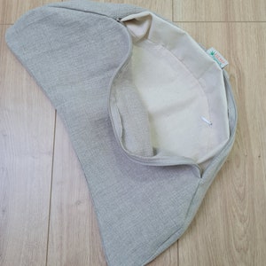 May include: A gray linen cushion cover with a zipper closure. The inside of the cover is white and has a green label that says "HEMP" with a green hemp leaf logo.