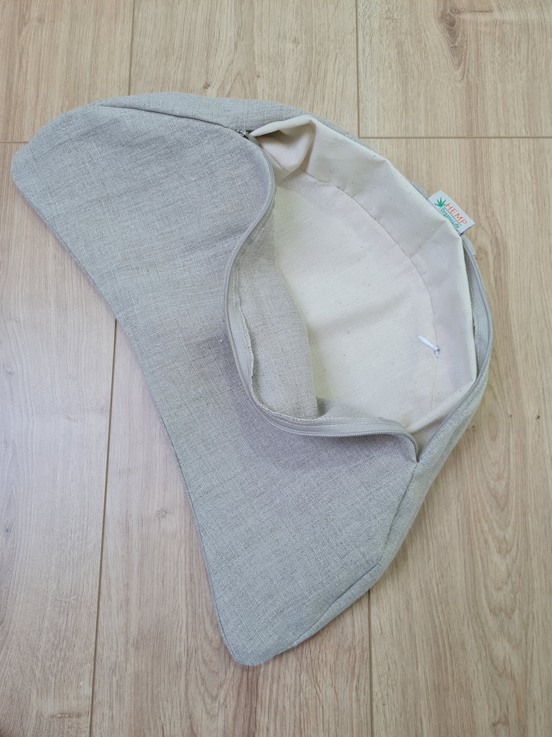 May include: A gray linen cushion cover with a zipper closure. The inside of the cover is white and has a green label that says "HEMP" with a green hemp leaf logo.