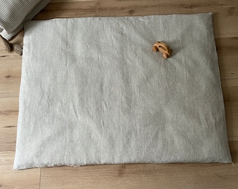 Könnte beinhalten: Eine graue Leinen-Spielmatte mit einem kleinen Holzspielzeugauto darauf.