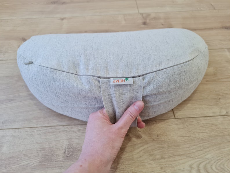 May include: A light gray hemp meditation cushion with a zipper closure and a label that reads "HEMP".