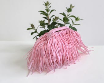 Bolsita de rafia rosa natural con flecos, forro de algodón floral y bolsillo interior, pieza artesanal.