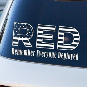 May include: A white vinyl sticker with the word "RED" in large letters, with each letter made up of an American flag design. The text "Remember Everyone Deployed" is below the word "RED".