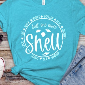 May include: A turquoise blue t-shirt with a white circle graphic that says "Just one more shell" with different types of shells around the text.