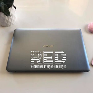 May include: A silver laptop with a white sticker that says "RED Remember Everyone Deployed" with an American flag design.