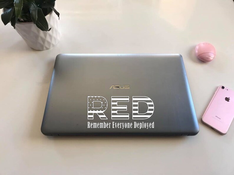 May include: A silver laptop with a white sticker that says "RED Remember Everyone Deployed" with an American flag design.