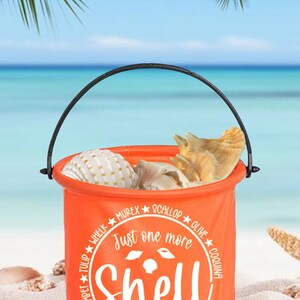 May include: Orange foldable bucket with a black handle filled with seashells. The bucket has a white circle with the text "Just one more shell" and the names of different types of shells around the circle.