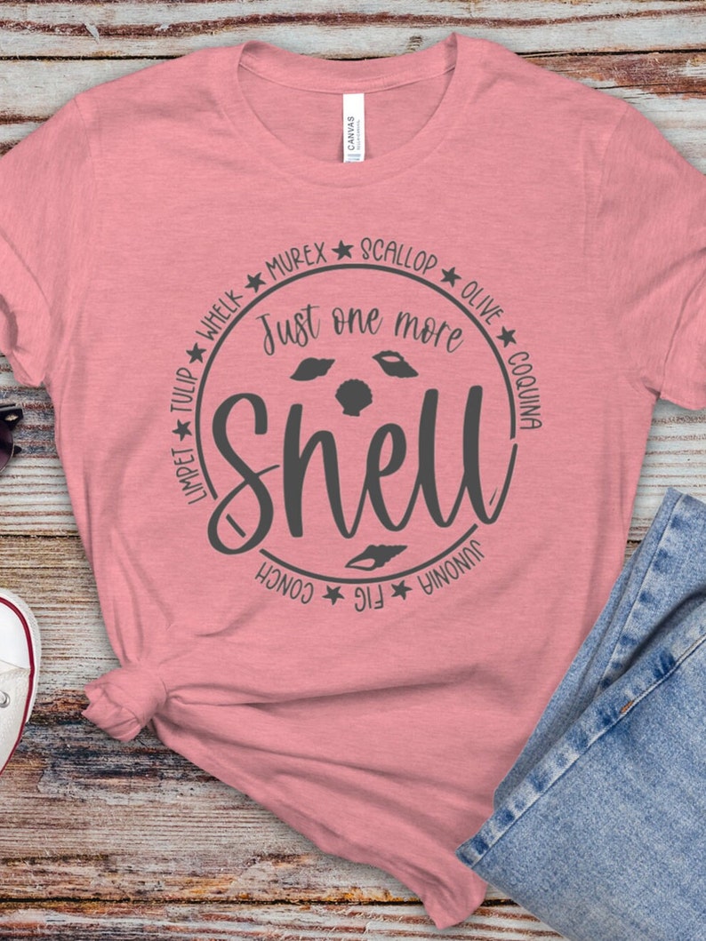 May include: A pink t-shirt with a gray circle design that says "Just one more shell" with the names of different types of shells around the circle.
