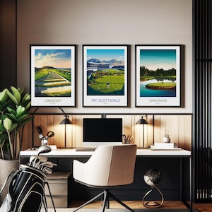 May include: Three framed golf course prints with black frames, featuring the Oakmont, TPC Scottsdale, and Sawgrass courses. The prints showcase vibrant green fairways, blue skies, and course details. The prints are displayed above a desk with a golf bag and desk accessories.