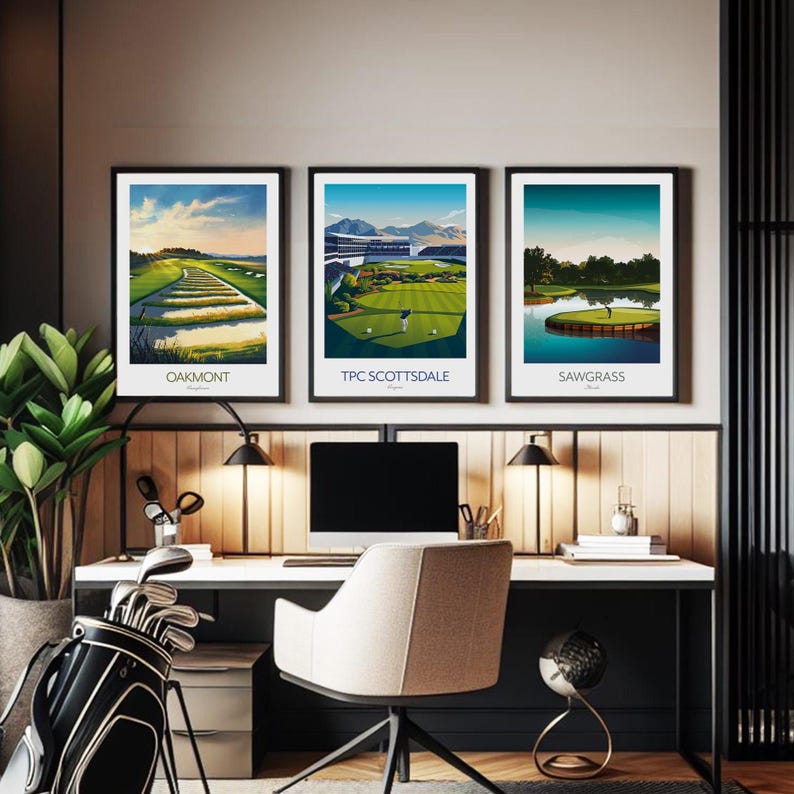 May include: Three framed golf course prints with black frames, featuring the Oakmont, TPC Scottsdale, and Sawgrass courses. The prints showcase vibrant green fairways, blue skies, and course details. The prints are displayed above a desk with a golf bag and desk accessories.