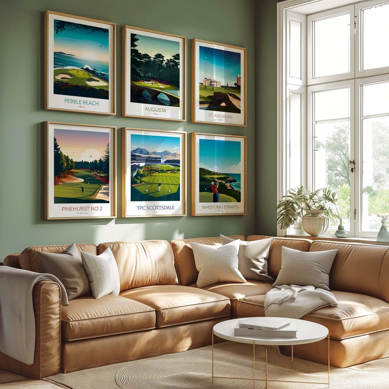 May include: Six framed golf course art prints, each featuring a different course: Pebble Beach, Augusta, St Andrews, Pinehurst No. 2, TPC Scottsdale, and Whistling Straits. The prints are displayed on a green wall above a brown leather sectional sofa.