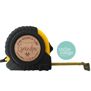 May include: A yellow and black tape measure with a wooden circle that says "No one measures up to our Grandpa Love Riley, Luna & Xavier".