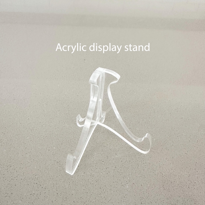 Puede incluir: Un soporte de exhibici&oacute;n transparente de acr&iacute;lico para mostrar art&iacute;culos peque&ntilde;os. El soporte tiene una forma triangular con una base ancha y una punta puntiaguda.