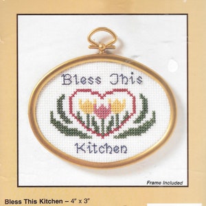 Puede incluir: Kit de punto de cruz ovalado con la frase "Bless This Kitchen". El diseño presenta un corazón con flores y hojas, enmarcado en un aro dorado. El marco mide 10.16 cm x 7.62 cm.