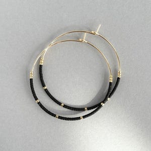 Aros con cuentas negras y doradas, delicados, dorados, con cuentas de semillas y sencillos.